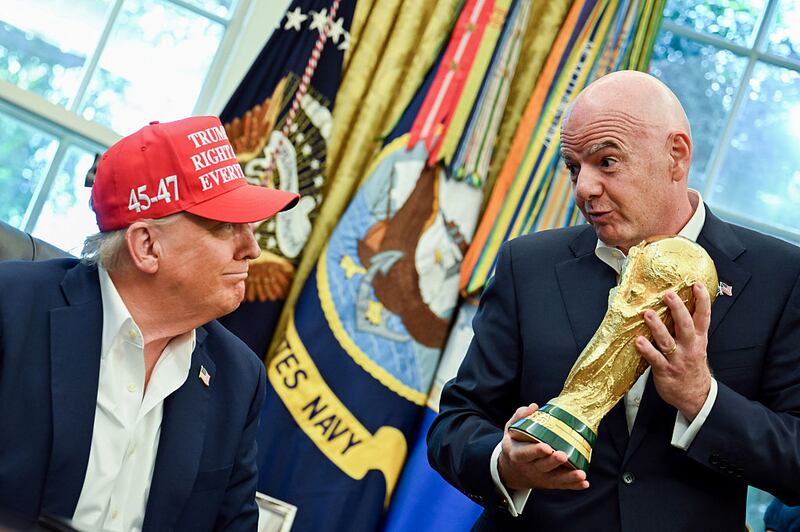 US President Donald Trump, left, and Gianni Infantino, president of the Federation International Football Association (FIFA), with the FIFA World Cup trophy in the Oval Office of the White House in Washington, DC, US, on Friday, Aug. 22, 2025. Trump announced that Washington's John F. Kennedy Center for the Performing Arts will host the draw for the 2026 FIFA World Cup. Photographer: Annabelle Gordon/UPI/Bloomberg via Getty Images