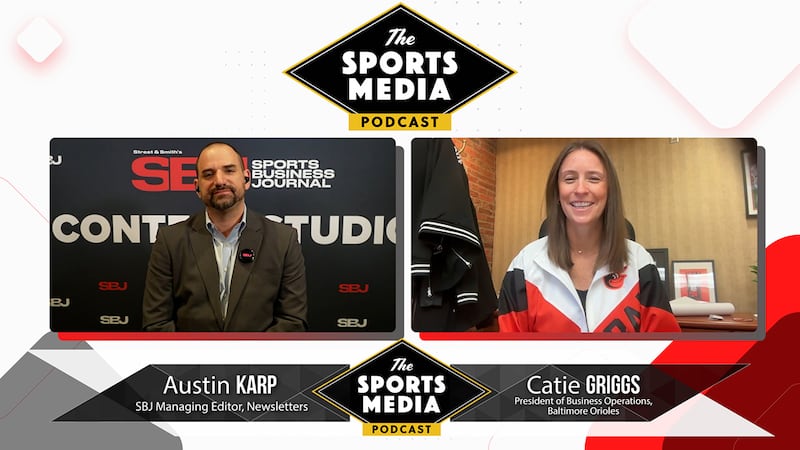 Orioles President/Business Operations Catie Griggs (woman on the right with long brown hair and a white/red jack) talks streaming and MASN with SBJ's Austin Karp (a balding man with a brown jacket and sitting in front of a Sports Business Journal call-out wall at the CAA World of Congress).