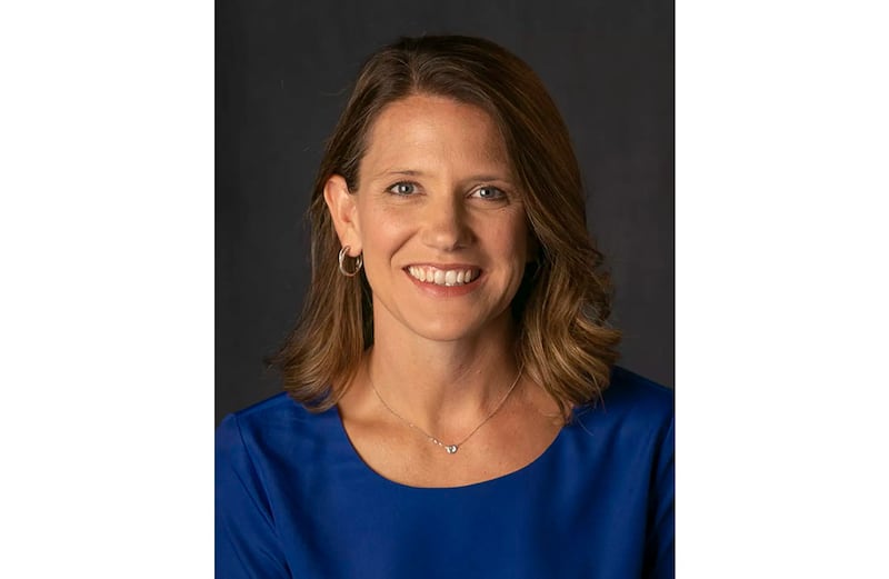 Kirsten Bernthal Booth smiles in a blue outfit.