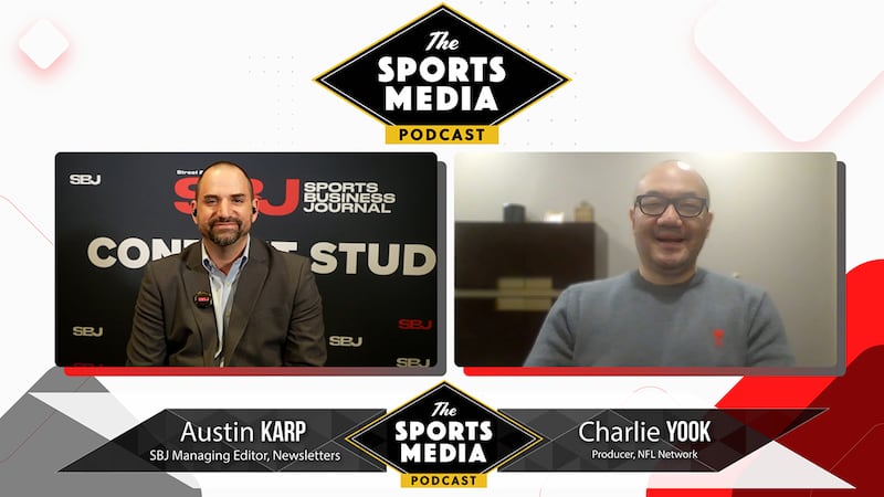 Austin Karp, left, a balding man with a jacket and goatee, talks to Charlie Yook, right, a bald man with glasses and a gray shirt, about the NFL Draft.