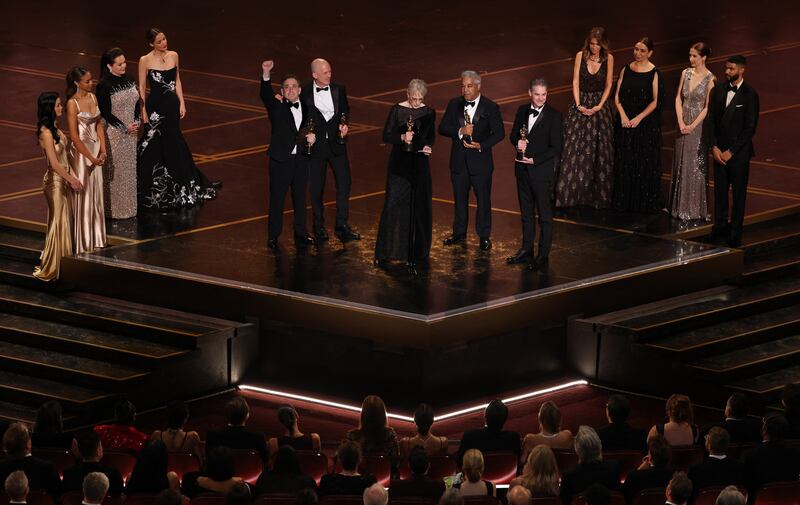 (C, L/R) US audio engineer Gary Rizzo, British audio engineer Gareth John, US sound editor Gwendolyn Yates Whittle, US sound mixer Juan Peralta and US audio engineer Al Nelson accept the award for Best Sound for "F1", flanked by US actress Melissa McCarthy (3L), Australian actress Rose Byrne (4L), US actress Kristen Wiig (4R), US actress Maya Rudolph (3R) and US actress Ellie Kemper onstage during the 98th Annual Academy Awards at the Dolby Theatre in Hollywood, California on March 15, 2026. (Photo by Patrick T. Fallon / AFP via Getty Images)