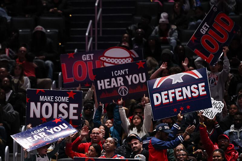 Fans hold signs during the second half of the game between the Washington Wizards and the Los Angeles Clippers at Capital One Arena on January 19, 2026.