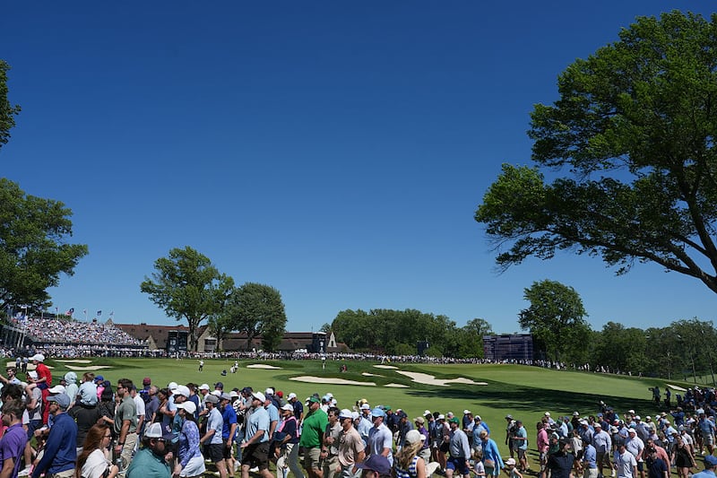 Fans cross the 18th fairway during the third round of PGA Championship at Aronimink Golf Club